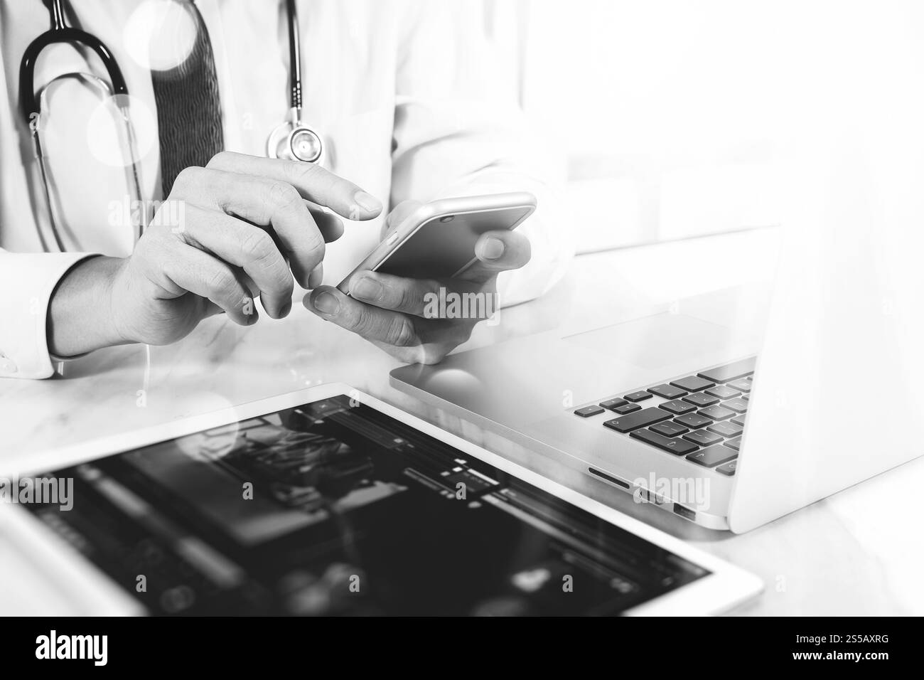 Concept de technologie médicale. Médecin part travailler avec tablette numérique moderne et ordinateur portable avec interface graphique médical, noir blanc Banque D'Images