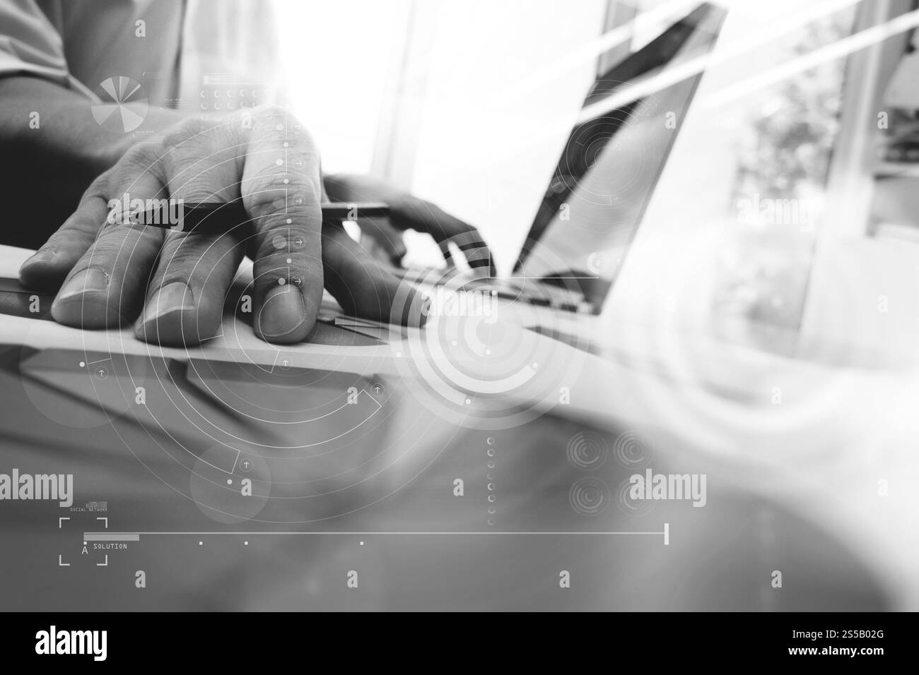 main d'homme d'affaires travaillant sur l'ordinateur portable avec le diagramme d'information graphique d'affaires de couche numérique sur le bureau en bois comme concept, noir et blanc Banque D'Images