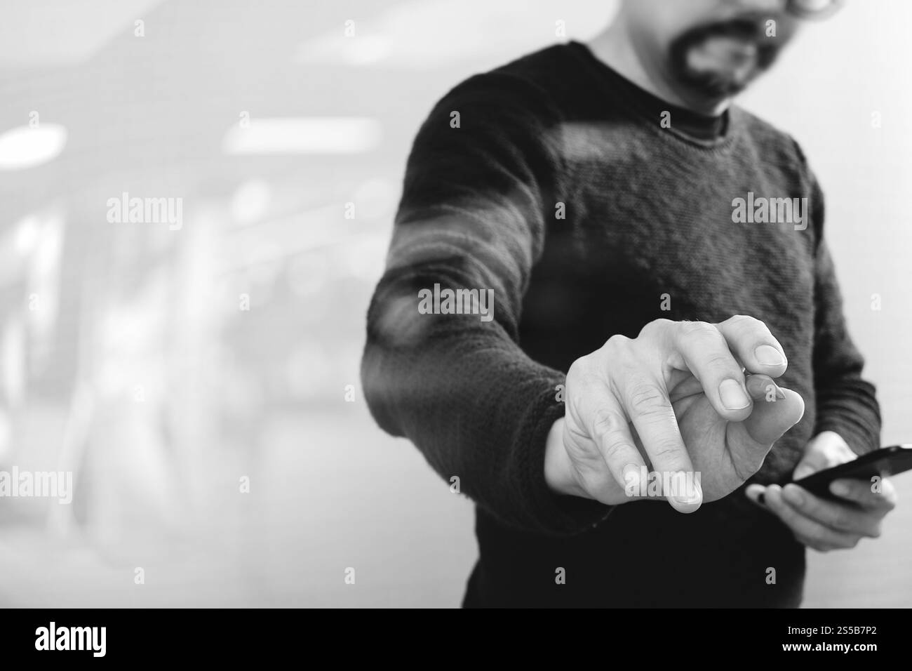 Businessman hand avec stylet appuyé sur un bouton imaginaire,holding smart phone,écran numérique vide virtuel graphique graphique icônes,schéma,Black,white Banque D'Images