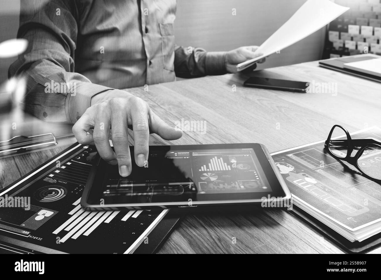 homme d'affaires travaillant avec la tablette numérique et le téléphone intelligent et l'ordinateur portable avec l'effet de couche de stratégie d'entreprise financière sur le bois Banque D'Images