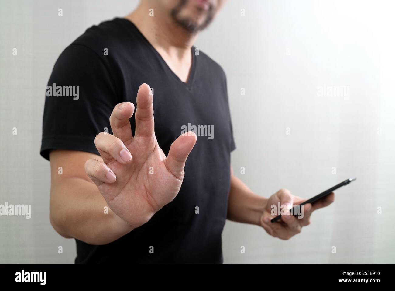 Businessman hand en appuyant sur un bouton imaginaire,holding smart phone,écran numérique virtuel graphique graphique,icônes,dessin Banque D'Images