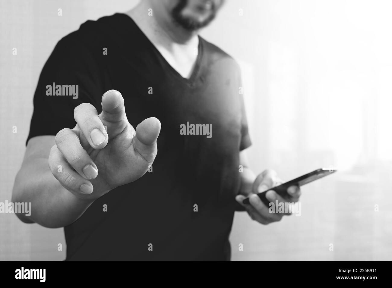 Businessman hand en appuyant sur un bouton imaginaire,holding smart phone,écran numérique vide virtuel graphique graphique icônes,schéma,Black,white Banque D'Images