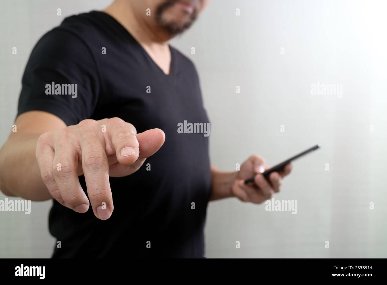 Businessman hand en appuyant sur un bouton imaginaire,holding smart phone,écran numérique virtuel graphique graphique,icônes,dessin Banque D'Images