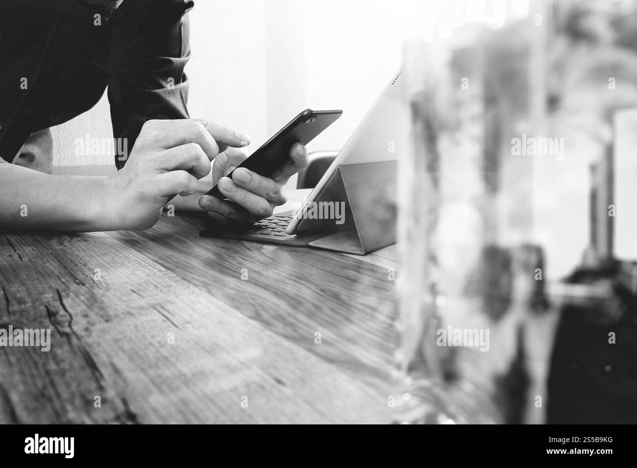main d'homme d'affaires utilisant le téléphone intelligent, paiements mobiles achats en ligne, omni canal, ordinateur de clavier d'amarrage de tablette numérique, vase en verre de fleur sur bois Banque D'Images