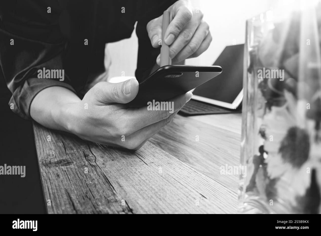main d'homme d'affaires avec stylo utilisant le téléphone intelligent, paiements mobiles achats en ligne, omni canal, ordinateur de clavier d'amarrage de tablette numérique, vase en verre de fleur Banque D'Images