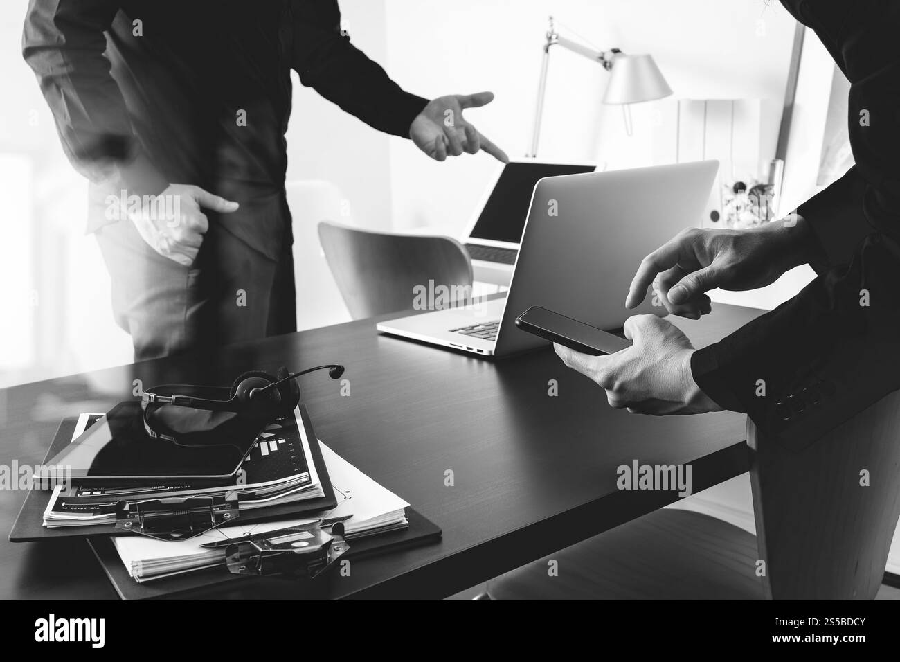 Co réunion de travail, deux hommes d'affaires utilisant le casque VoIP avec ordinateur latop sur le bureau dans le bureau moderne comme centre d'appels et bureau d'assistance de service à la clientèle Banque D'Images