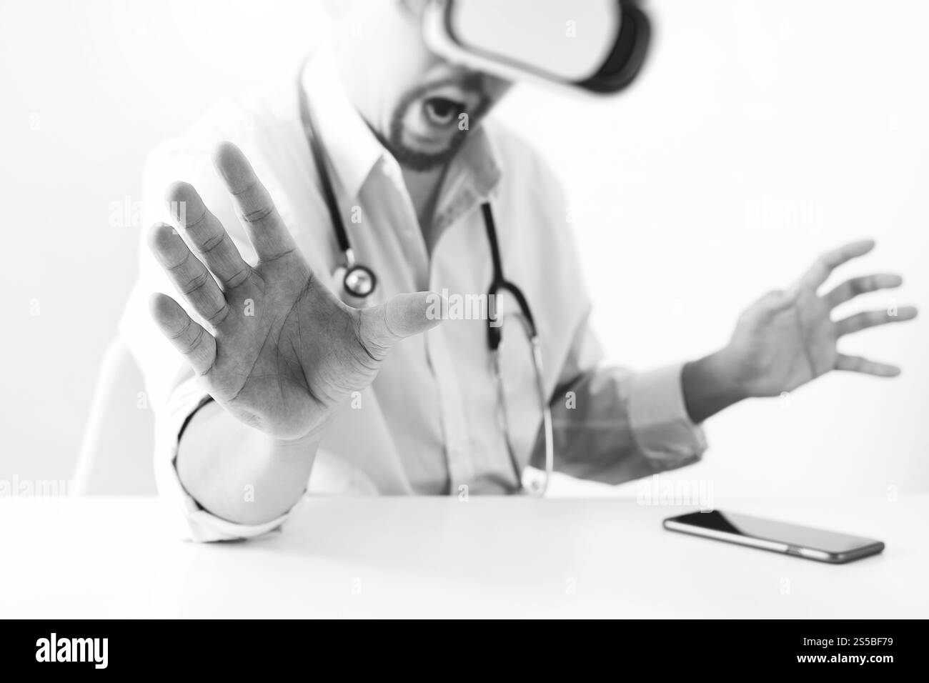 Smart médecin portant des lunettes de réalité virtuelle dans un bureau moderne avec téléphone portable à l'aide de casque VR avec noir et blanc, Banque D'Images