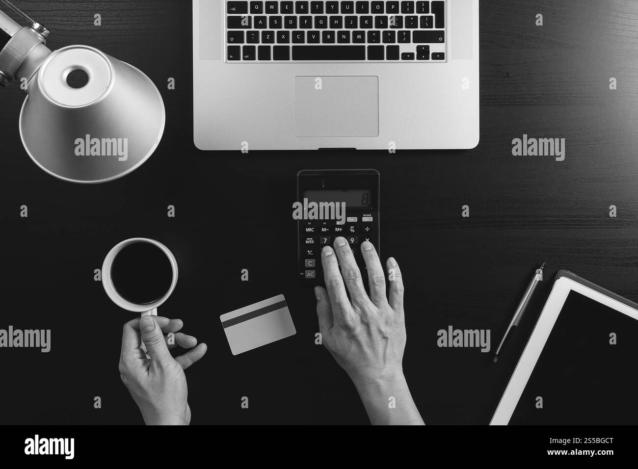 Concept d'achat sur Internet. Vue de dessus des mains travaillant avec la calculatrice et l'ordinateur portable et la carte de crédit et l'ordinateur tablette sur la table en bois foncé Banque D'Images