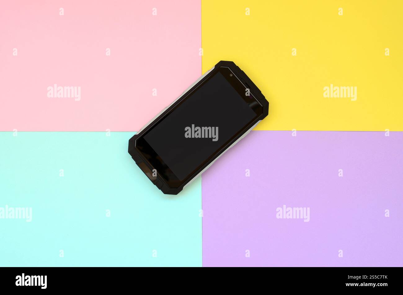 Smartphone résistant aux chocs noir repose sur un fond de couleur pastel. Concept de technologie moderne. Minimalisme pose à plat. Corail vivant, violet, jaune et Banque D'Images