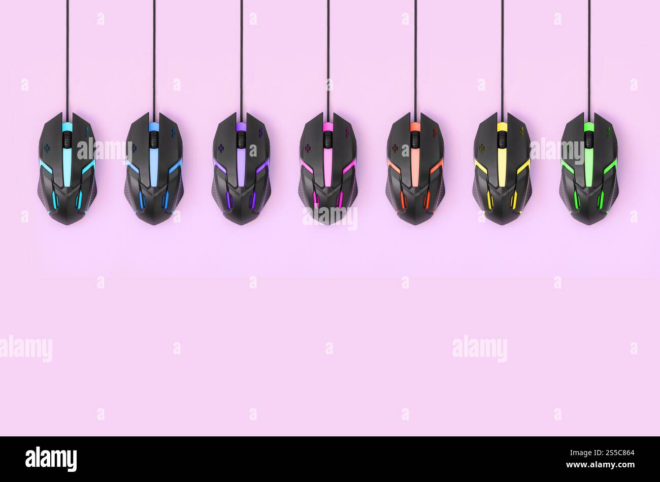 Plusieurs souris d'ordinateur accrochent sur un fond rose pastel. Le concept de jeux vidéo informatiques coopératifs, l'utilisation de l'auto-clicker et pay-per-click Banque D'Images