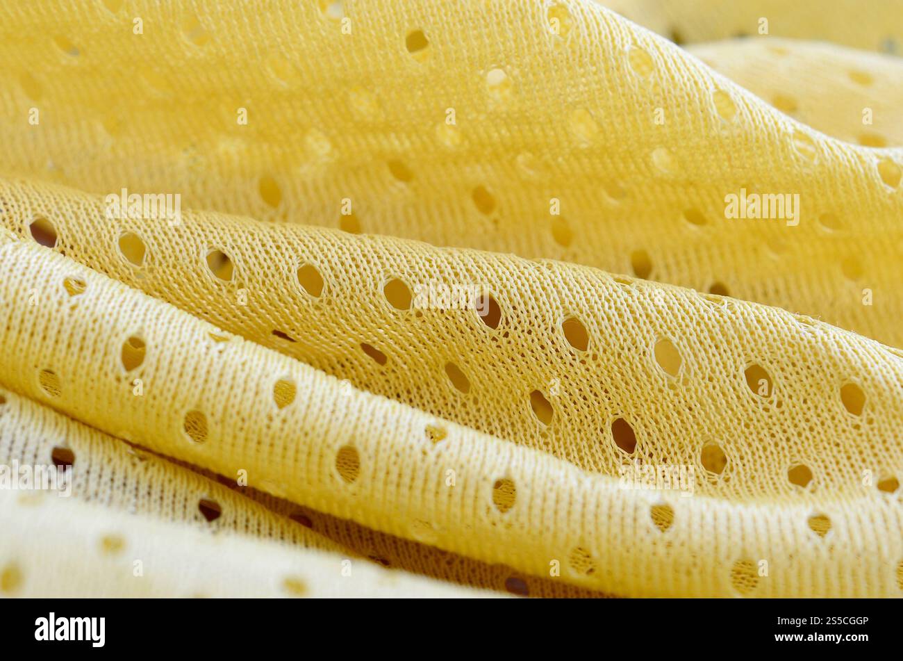Fond de modèle textile de tissu de tissu de sport de maille jaune. Couleur jaune maillot de football vêtements tissu texture vêtements de sport. Poreux respirant Banque D'Images