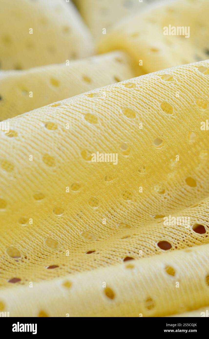 Fond de modèle textile de tissu de tissu de sport de maille jaune. Couleur jaune maillot de football vêtements tissu texture vêtements de sport. Poreux respirant Banque D'Images