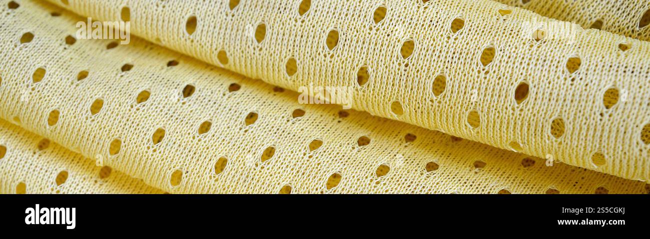Fond de modèle textile de tissu de tissu de sport de maille jaune. Couleur jaune maillot de football vêtements tissu texture vêtements de sport. Poreux respirant Banque D'Images