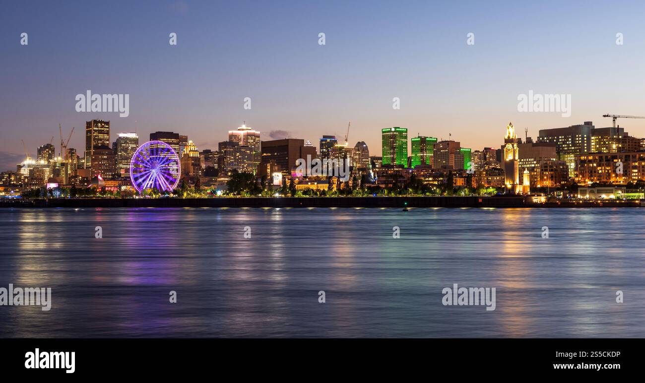Vieux-Port de Montréal et horizon du centre-ville la nuit. Les lumières colorées des bâtiments se reflètent dans l'eau. Montréal, Québec, Canada. Banque D'Images