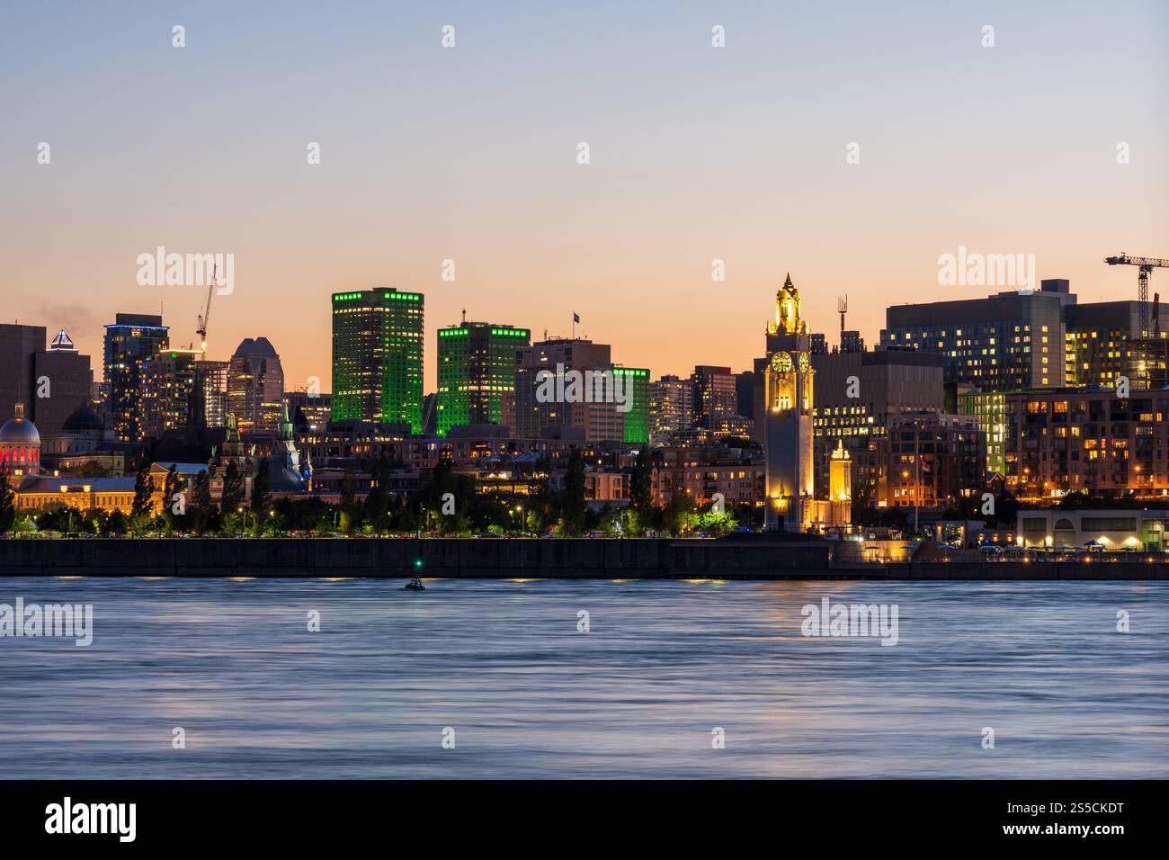 Vieux-Port de Montréal et horizon du centre-ville la nuit. Les lumières colorées des bâtiments se reflètent dans l'eau. Montréal, Québec, Canada. Tour d'horloge. Banque D'Images