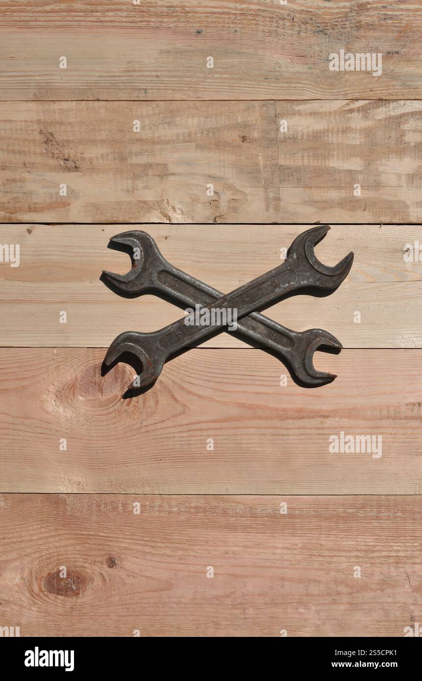 Quelques clés rouillées sur un fond en bois. Des outils ménagers obsolètes en métal rouillé reposent sur une table en bois dans un atelier. Le concept de réparation Banque D'Images