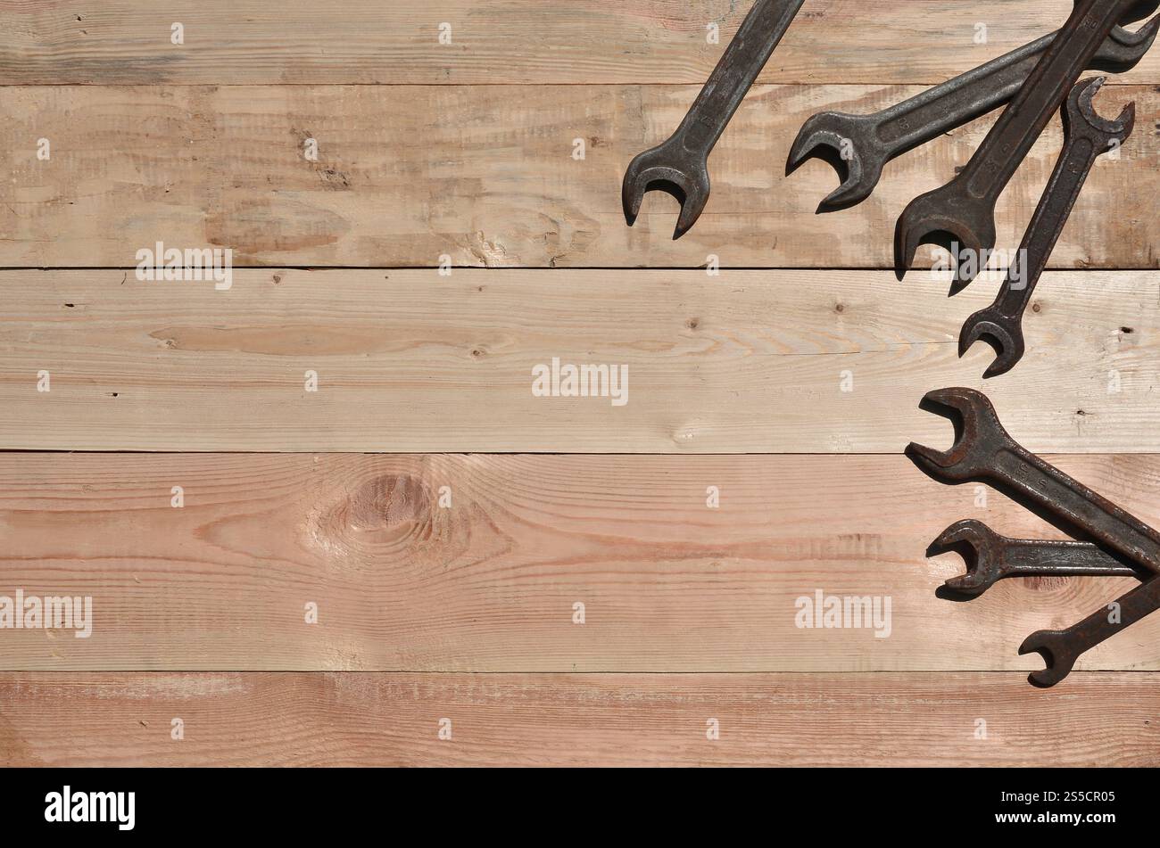 Quelques clés rouillées sur un fond en bois. Des outils ménagers obsolètes en métal rouillé reposent sur une table en bois dans un atelier. Le concept de réparation Banque D'Images