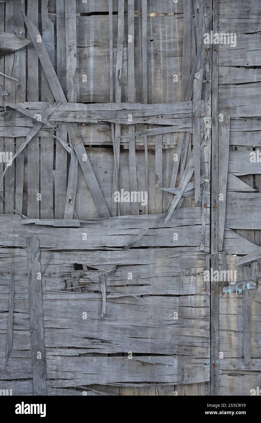 La texture du mur en bois brisé gris altéré. Clôture en planche de bois vieilli de feuilles de bois fissurées. Texture murale en bois Banque D'Images