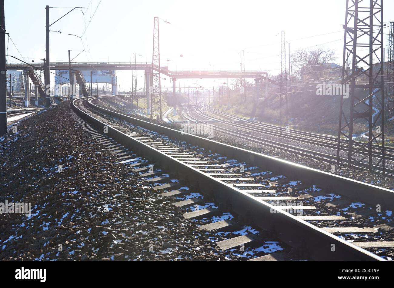Paysage d'un chemin de fer d'hiver russe enneigé sous la lumière du soleil les rails et les traverses sous la neige de décembre. Chemins de fer russes en détail. Hiver Banque D'Images
