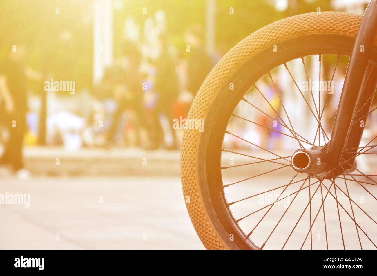 Une roue de vélo BMX dans le contexte d'une rue avec des coureurs cyclistes brouillée. Extreme Sports Concept Banque D'Images Une roue de vélo BMX dans le contexte d'une rue avec des coureurs cyclistes brouillée. Extreme Sports Concept Banque D'Images