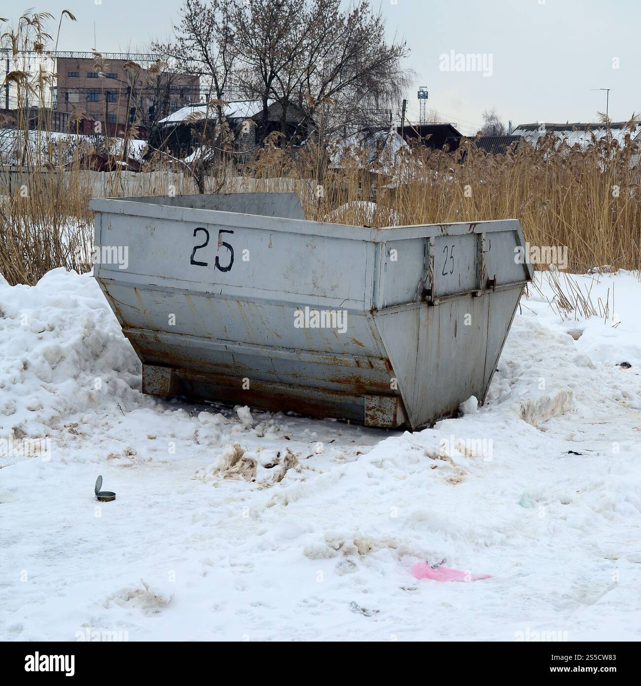 Poubelle sur le côté de la rue en hiver avec bac à déchets à lèvres hiver neige. Conteneur métallique pour déchets ménagers Banque D'Images