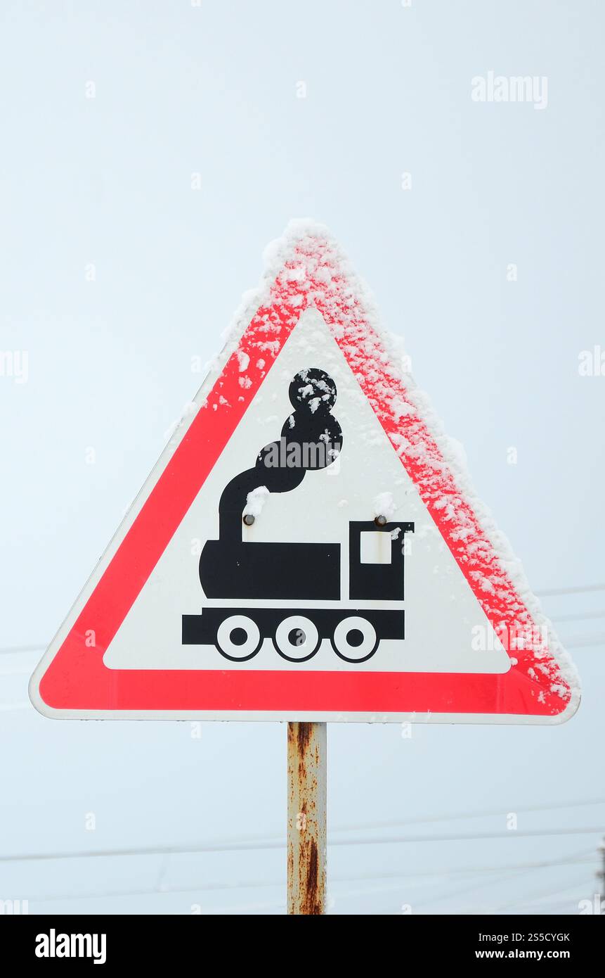 Passage de chemin de fer sans barrière. Un panneau routier représentant une vieille locomotive noire, situé dans un triangle rouge Banque D'Images