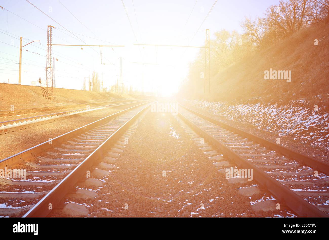 Paysage d'un chemin de fer d'hiver russe enneigé sous la lumière du soleil les rails et les traverses sous la neige de décembre. Chemins de fer russes en détail. Hiver Banque D'Images
