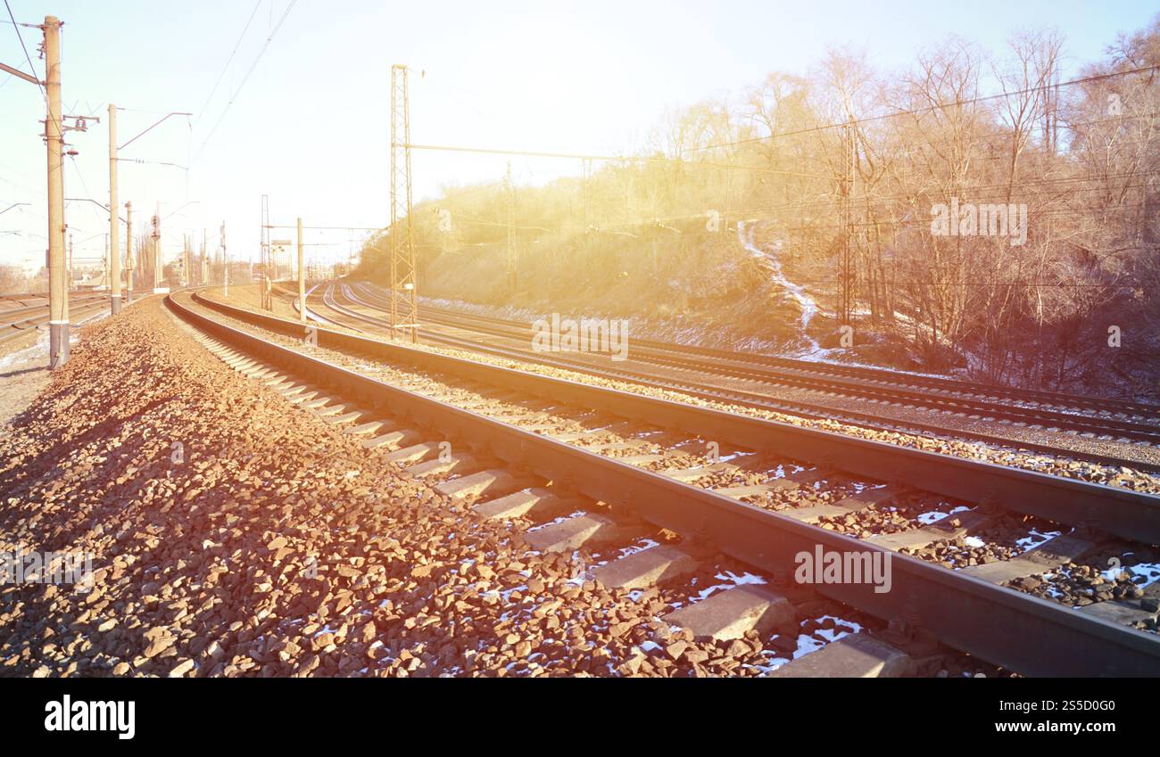 Paysage d'un chemin de fer d'hiver russe enneigé sous la lumière du soleil les rails et les traverses sous la neige de décembre. Chemins de fer russes en détail. Hiver Banque D'Images