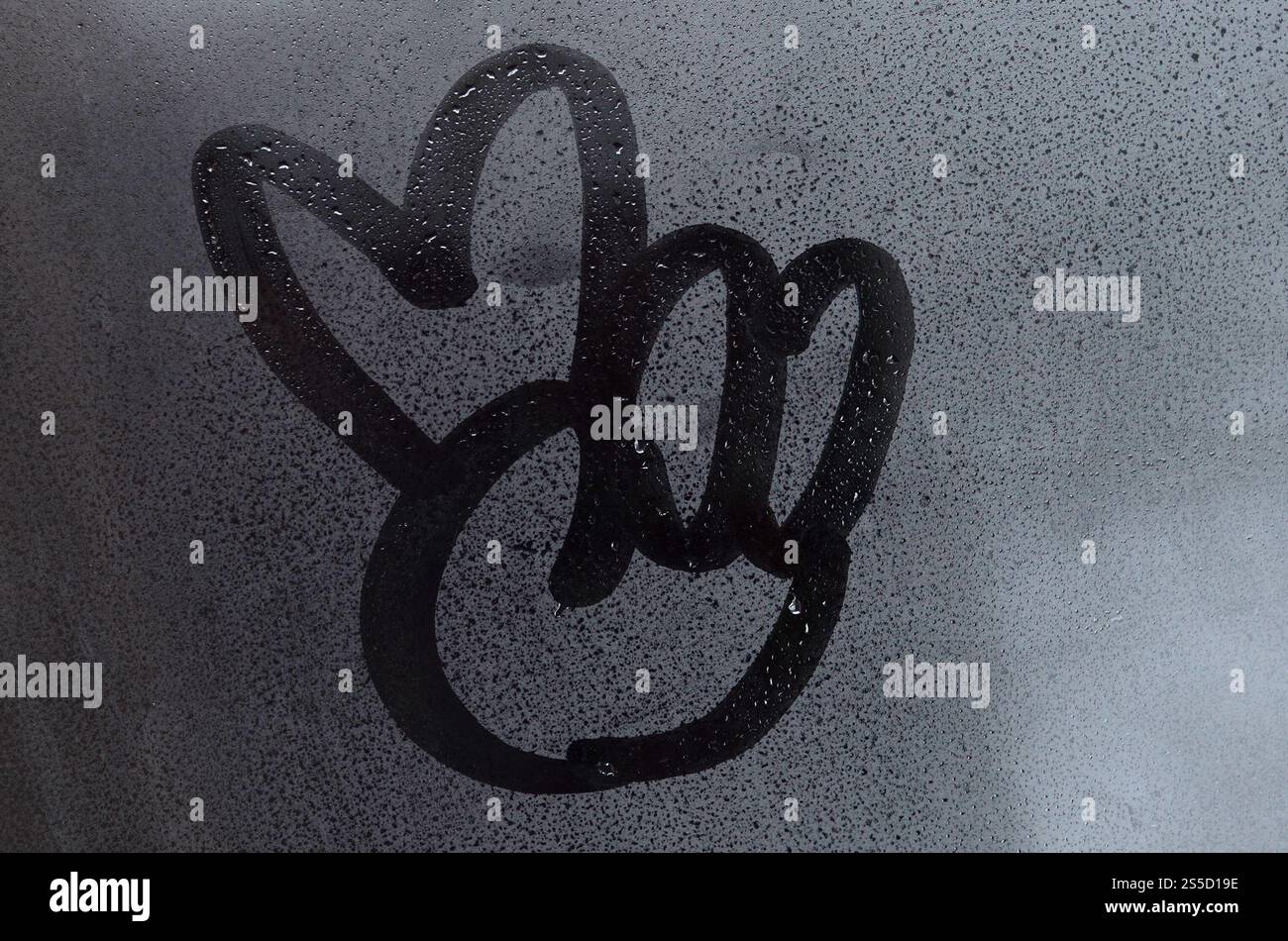 L'image du symbole de paix est dessinée avec un doigt sur la surface d'une fenêtre en verre embué. Combinaison de deux doigts Banque D'Images