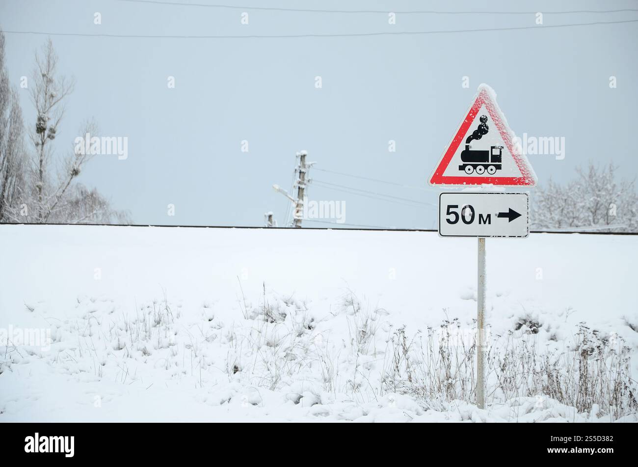 Passage de chemin de fer sans barrière. Un panneau routier représentant une vieille locomotive noire, situé dans un triangle rouge Banque D'Images