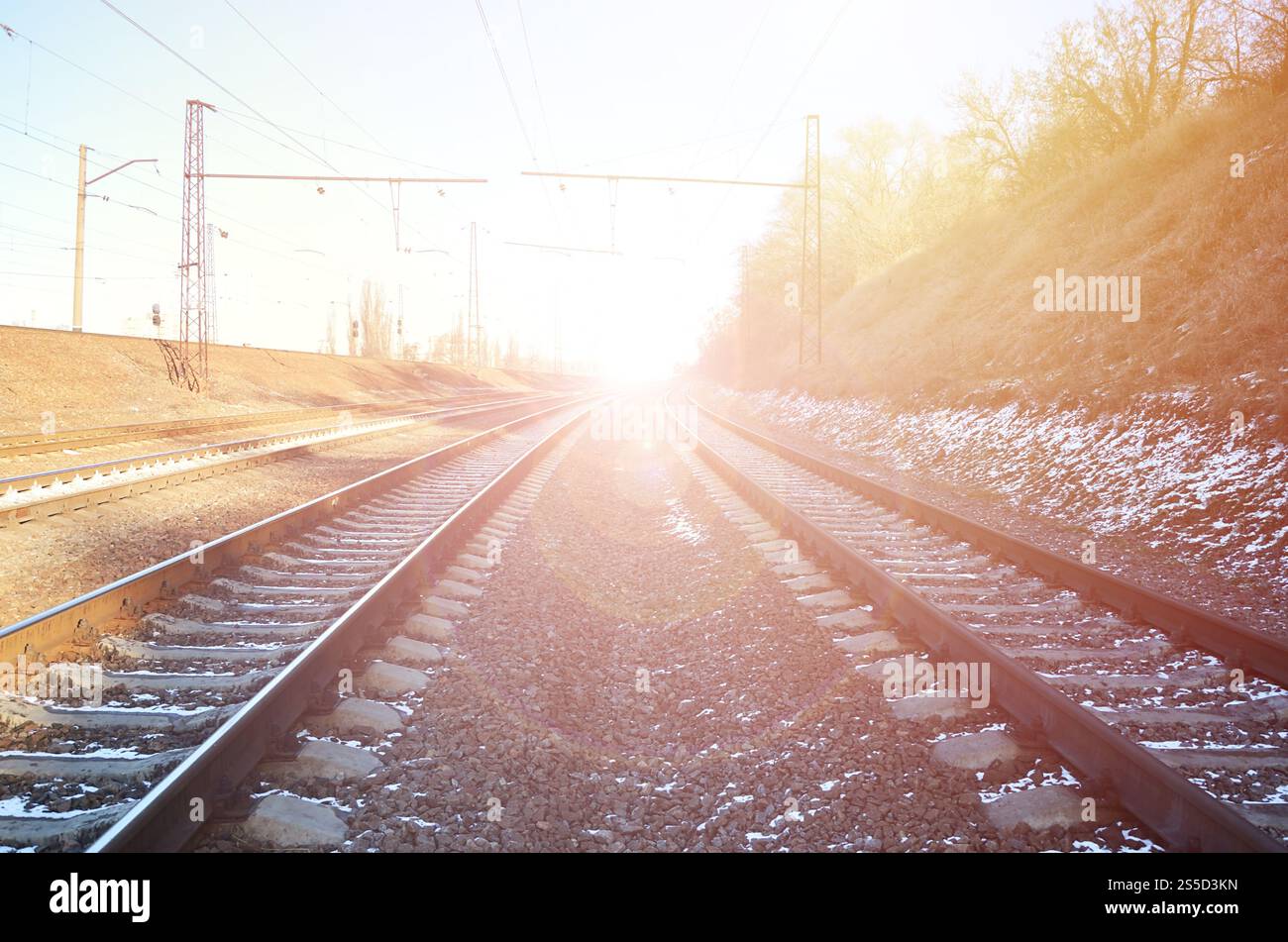 Paysage d'un chemin de fer d'hiver russe enneigé sous la lumière du soleil les rails et les traverses sous la neige de décembre. Chemins de fer russes en détail. Hiver Banque D'Images