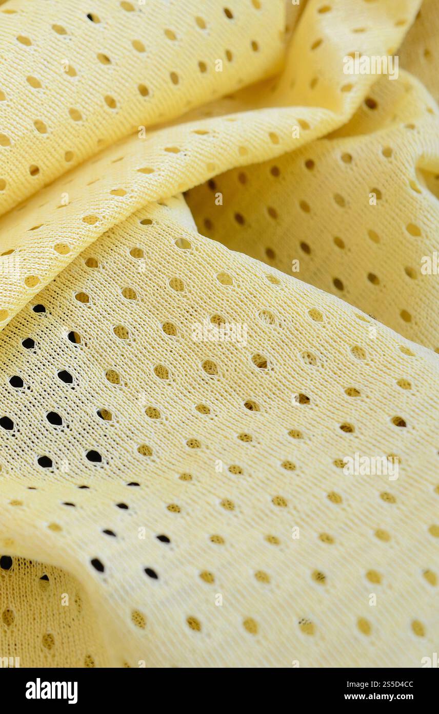 Fond de modèle textile de tissu de tissu de sport de maille jaune. Couleur jaune maillot de football vêtements tissu texture vêtements de sport. Poreux respirant Banque D'Images