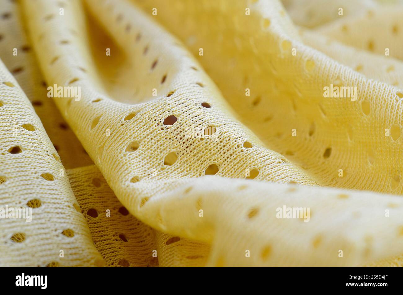Fond de modèle textile de tissu de tissu de sport de maille jaune. Couleur jaune maillot de football vêtements tissu texture vêtements de sport. Poreux respirant Banque D'Images