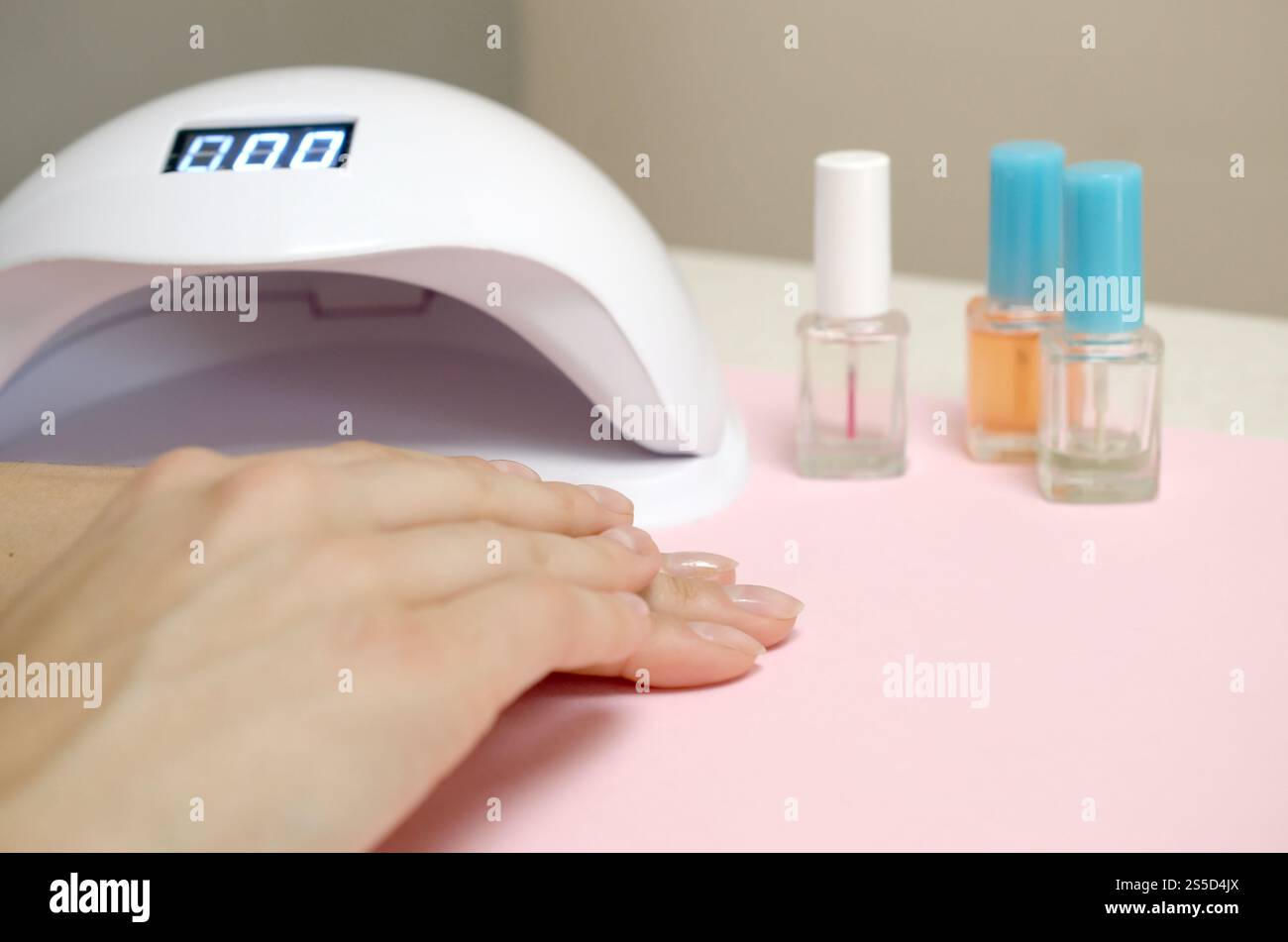 Close up femme mains avec de beaux ongles transparent branché sur l'arrière-plan du tableau blanc. Différents outils modernes pour faire une longue durée polish gel Banque D'Images