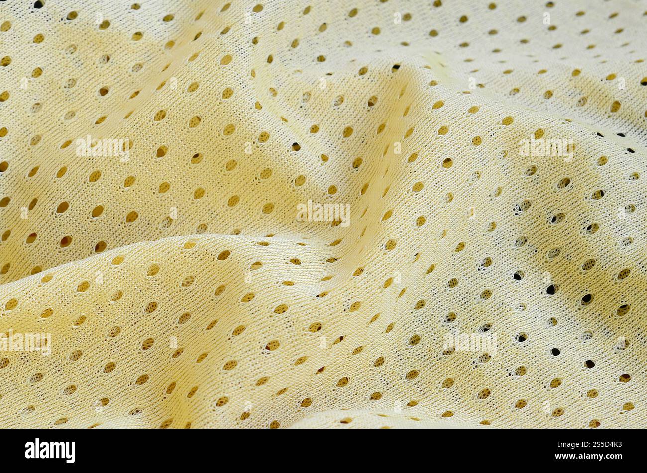 Fond de modèle textile de tissu de tissu de sport de maille jaune. Couleur jaune maillot de football vêtements tissu texture vêtements de sport. Poreux respirant Banque D'Images