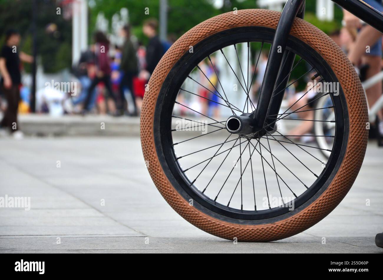Une roue de vélo BMX dans le contexte d'une rue avec des coureurs cyclistes brouillée. Extreme Sports Concept Banque D'Images Une roue de vélo BMX dans le contexte d'une rue avec des coureurs cyclistes brouillée. Extreme Sports Concept Banque D'Images