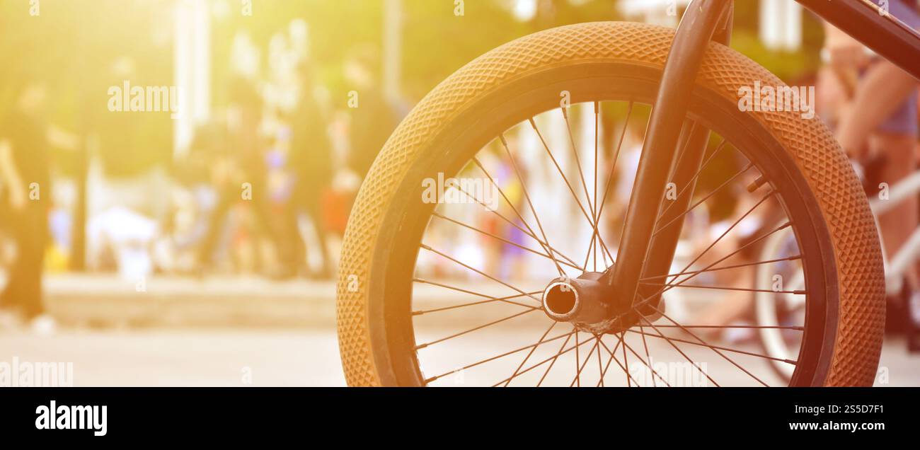 Une roue de vélo BMX dans le contexte d'une rue avec des coureurs cyclistes brouillée. Extreme Sports Concept Banque D'Images Une roue de vélo BMX dans le contexte d'une rue avec des coureurs cyclistes brouillée. Extreme Sports Concept Banque D'Images