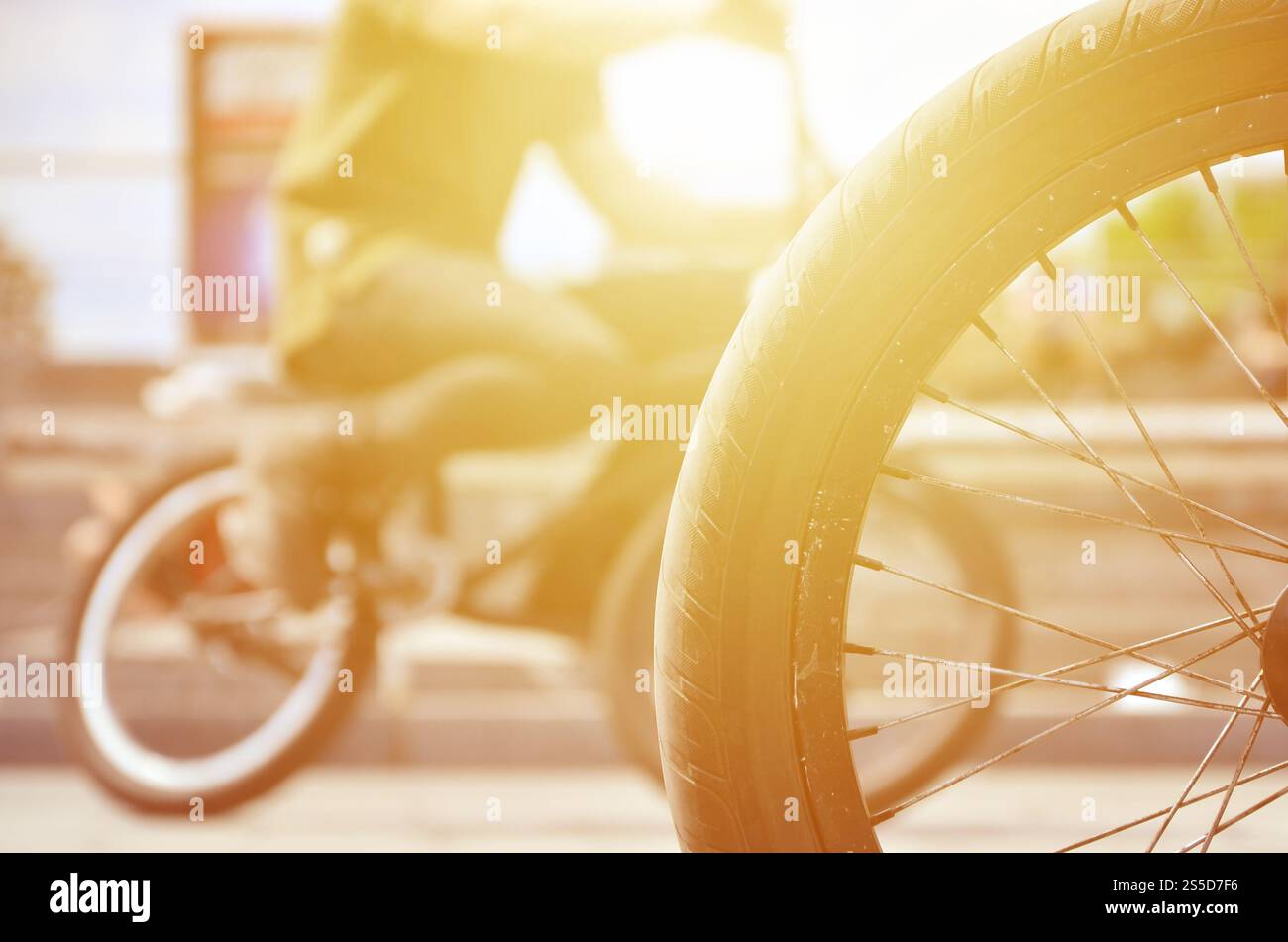 Une roue de vélo BMX dans le contexte d'une rue avec des coureurs cyclistes brouillée. Extreme Sports Concept Banque D'Images Une roue de vélo BMX dans le contexte d'une rue avec des coureurs cyclistes brouillée. Extreme Sports Concept Banque D'Images