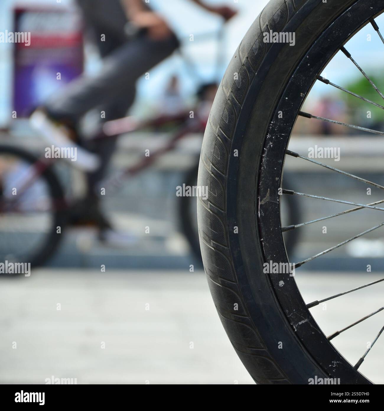 Une roue de vélo BMX dans le contexte d'une rue avec des coureurs cyclistes brouillée. Extreme Sports Concept Banque D'Images Une roue de vélo BMX dans le contexte d'une rue avec des coureurs cyclistes brouillée. Extreme Sports Concept Banque D'Images
