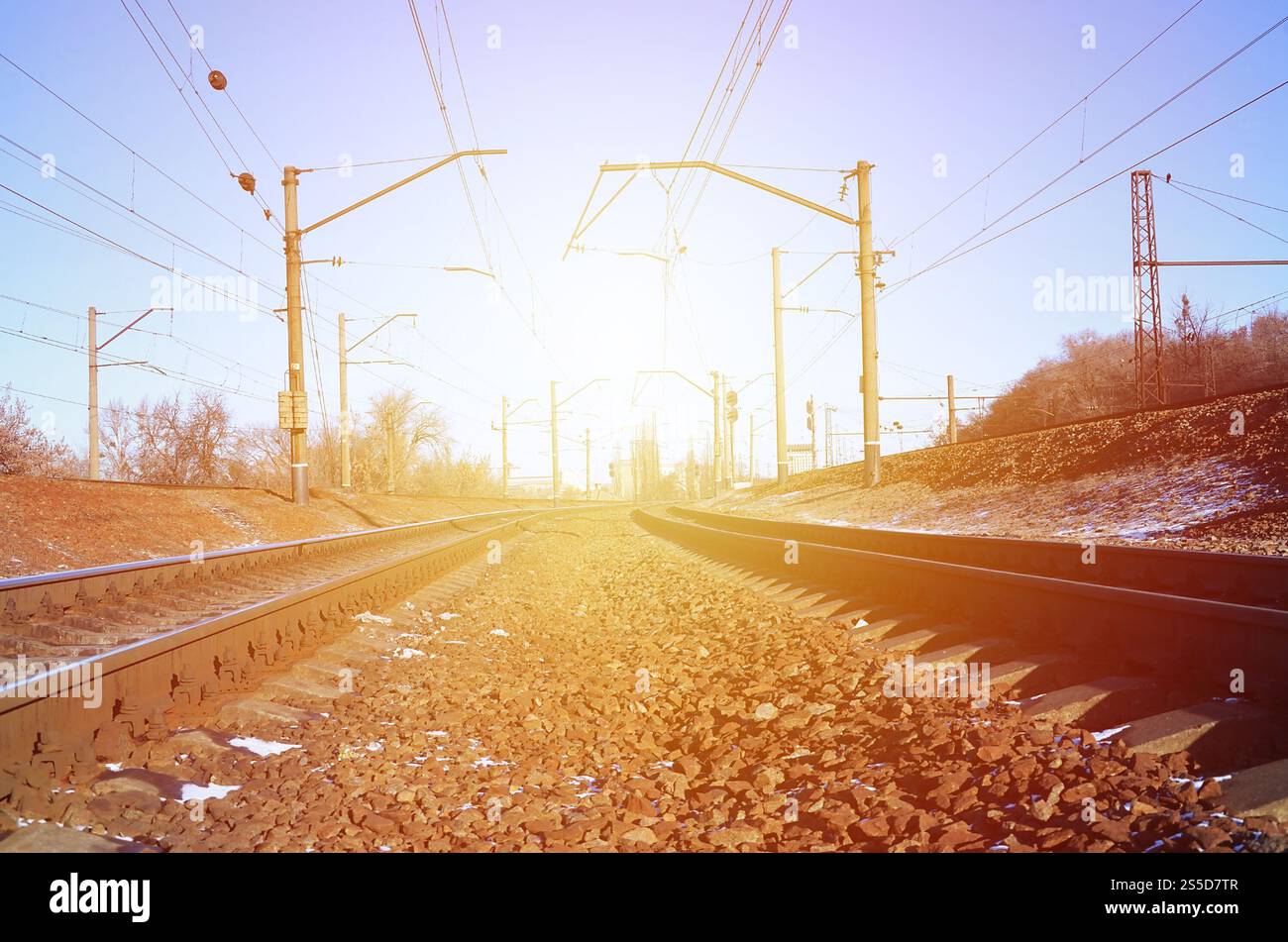 Paysage d'un chemin de fer d'hiver russe enneigé sous la lumière du soleil les rails et les traverses sous la neige de décembre. Chemins de fer russes en détail. Hiver Banque D'Images