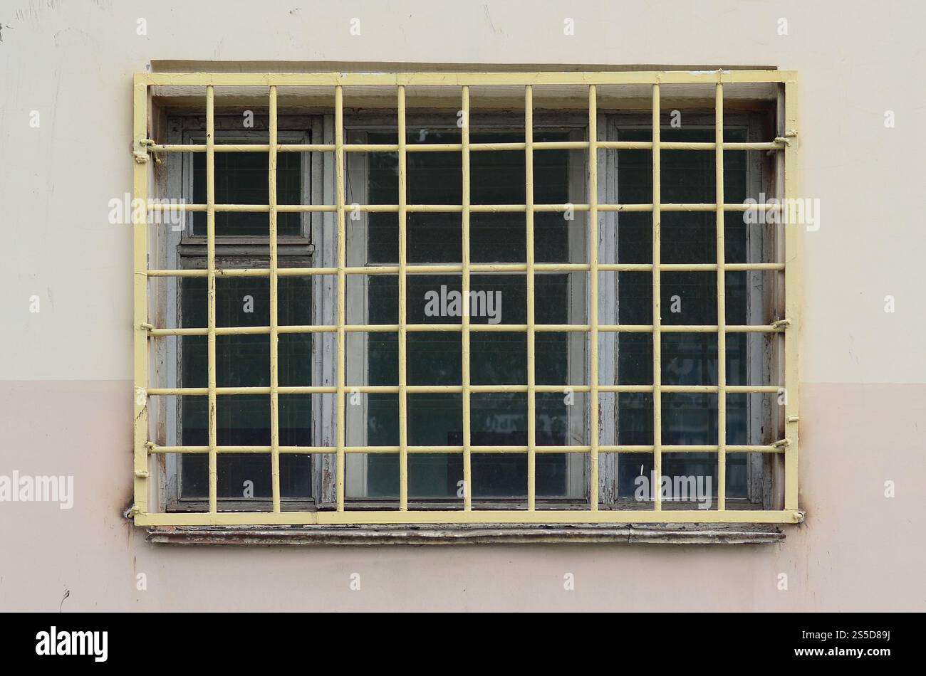 La texture du mur d'un immeuble résidentiel avec une fenêtre qui est protégé par une grille métallique. Ancienne méthode de protection du carter de brigands Banque D'Images