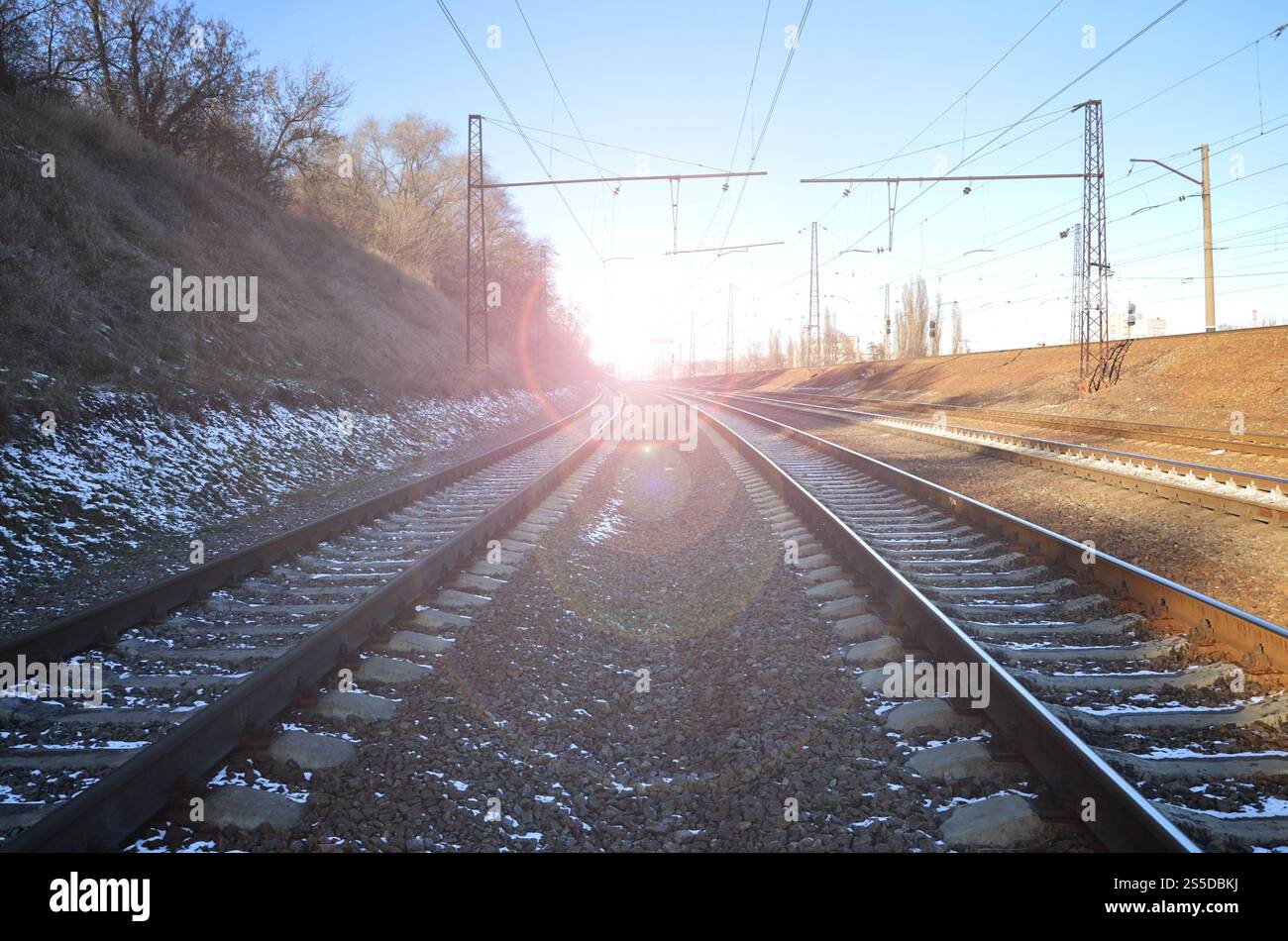 Paysage d'un chemin de fer d'hiver russe enneigé sous la lumière du soleil les rails et les traverses sous la neige de décembre. Chemins de fer russes en détail. Hiver Banque D'Images