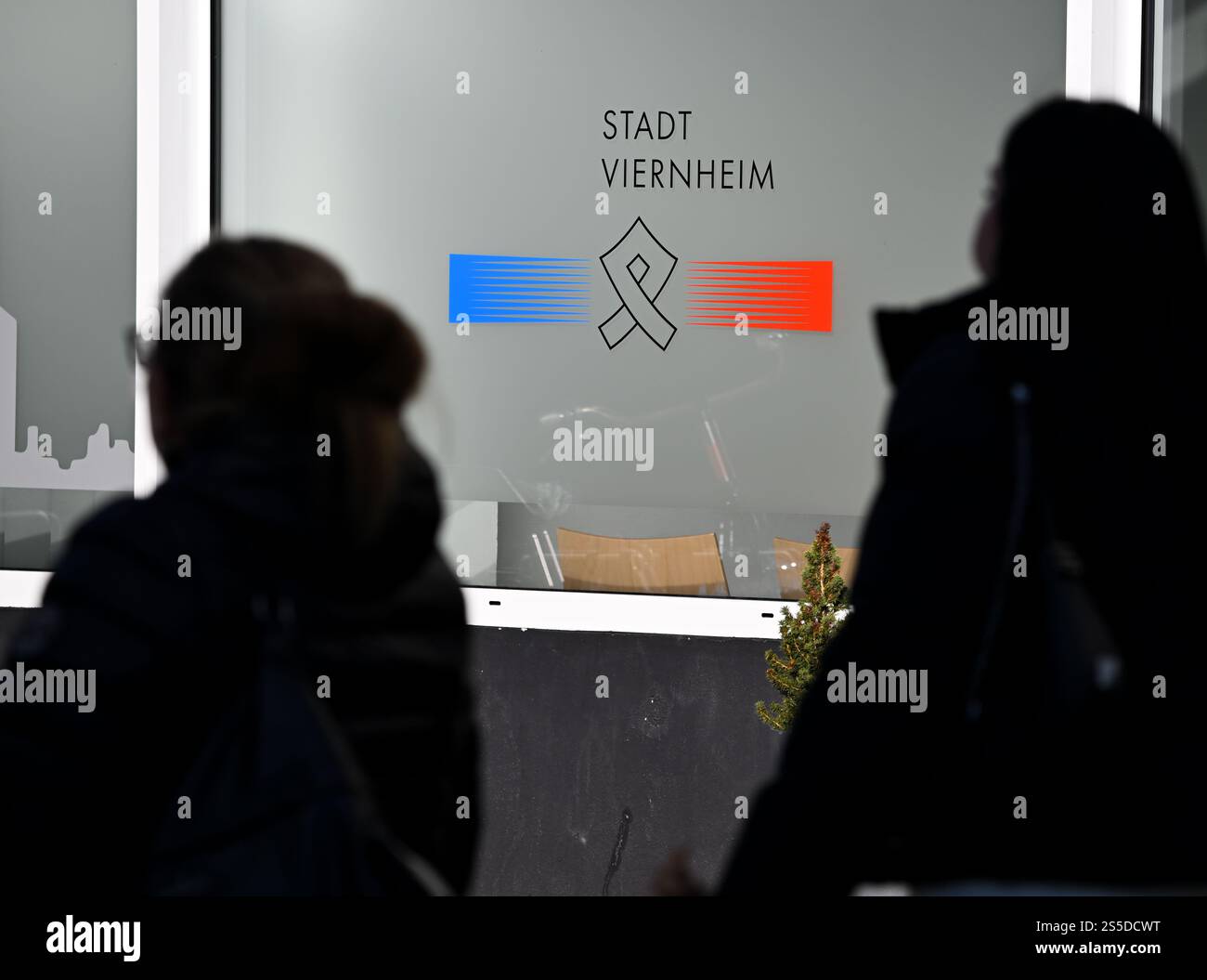 Viernheim, Allemagne. 14 janvier 2025. Deux femmes passent devant la mairie de Viernheim sur Apostelplatz. Aucun feu d'artifice ne peut être déclenché dans certaines parties du centre-ville de Viernheim la veille du nouvel an. Cela a été décidé par le conseil municipal de la ville de Hesse méridionale. Plus précisément, la zone autour de l'église de l'Apôtre et la zone environnante est touchée. Crédit : Arne Dedert/dpa/Alamy Live News Banque D'Images