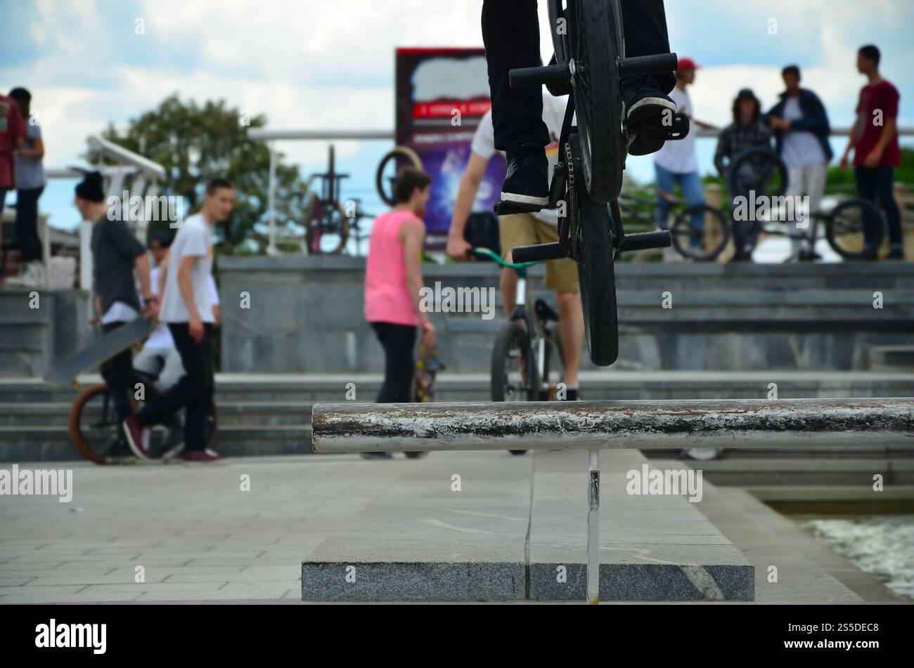 Un cycliste saute par-dessus un tuyau sur un vélo BMX. Beaucoup de gens avec des vélos en arrière-plan. Concept de sports extrêmes Banque D'Images Un cycliste saute par-dessus un tuyau sur un vélo BMX. Beaucoup de gens avec des vélos en arrière-plan. Concept de sports extrêmes Banque D'Images