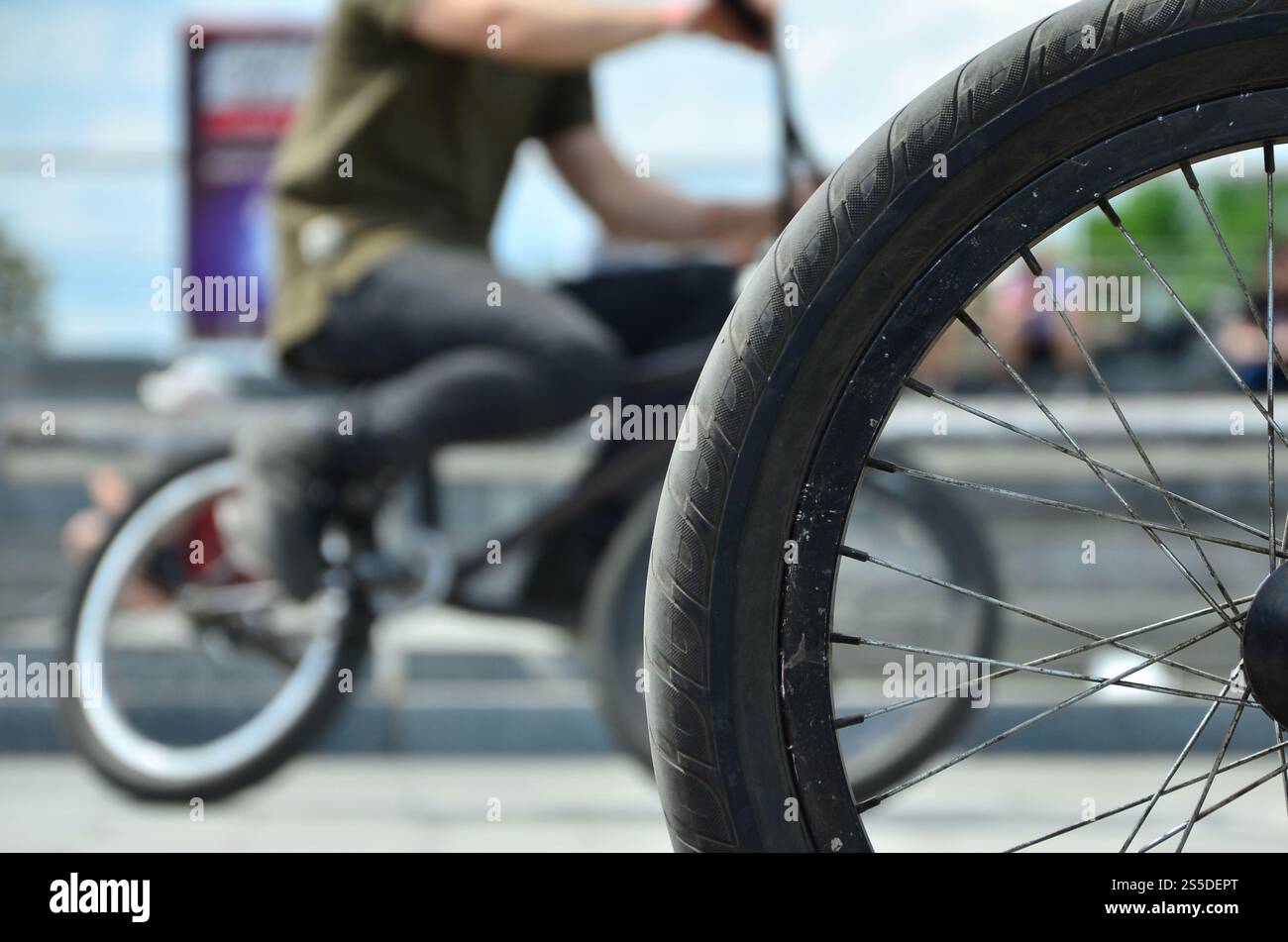 Une roue de vélo BMX dans le contexte d'une rue avec des coureurs cyclistes brouillée. Extreme Sports Concept Banque D'Images Une roue de vélo BMX dans le contexte d'une rue avec des coureurs cyclistes brouillée. Extreme Sports Concept Banque D'Images