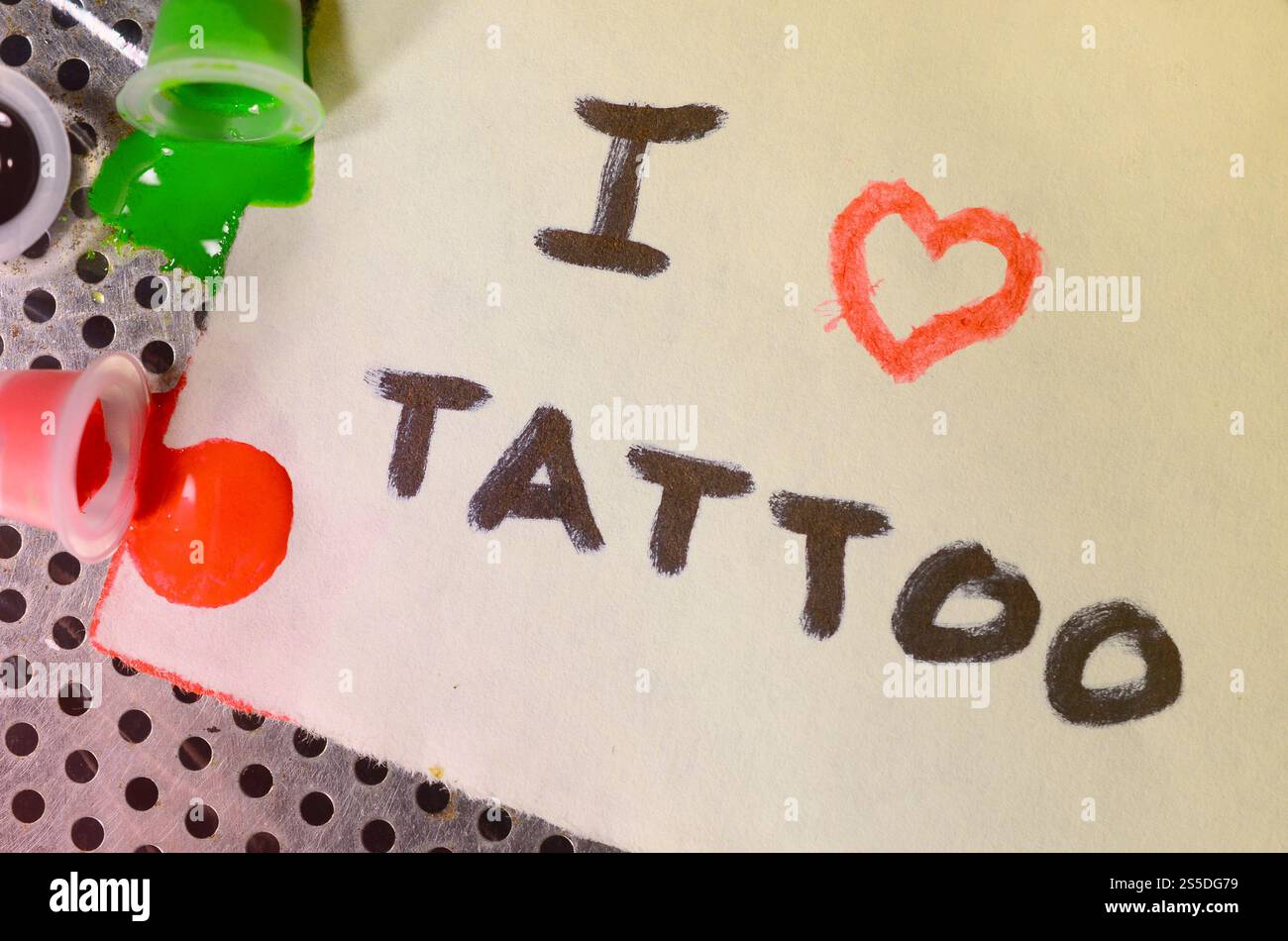 J'adore le tatouage. Le texte est écrit sur une petite feuille de papier à côté des capuchons rentournés avec de l'encre tattoo colorée Banque D'Images