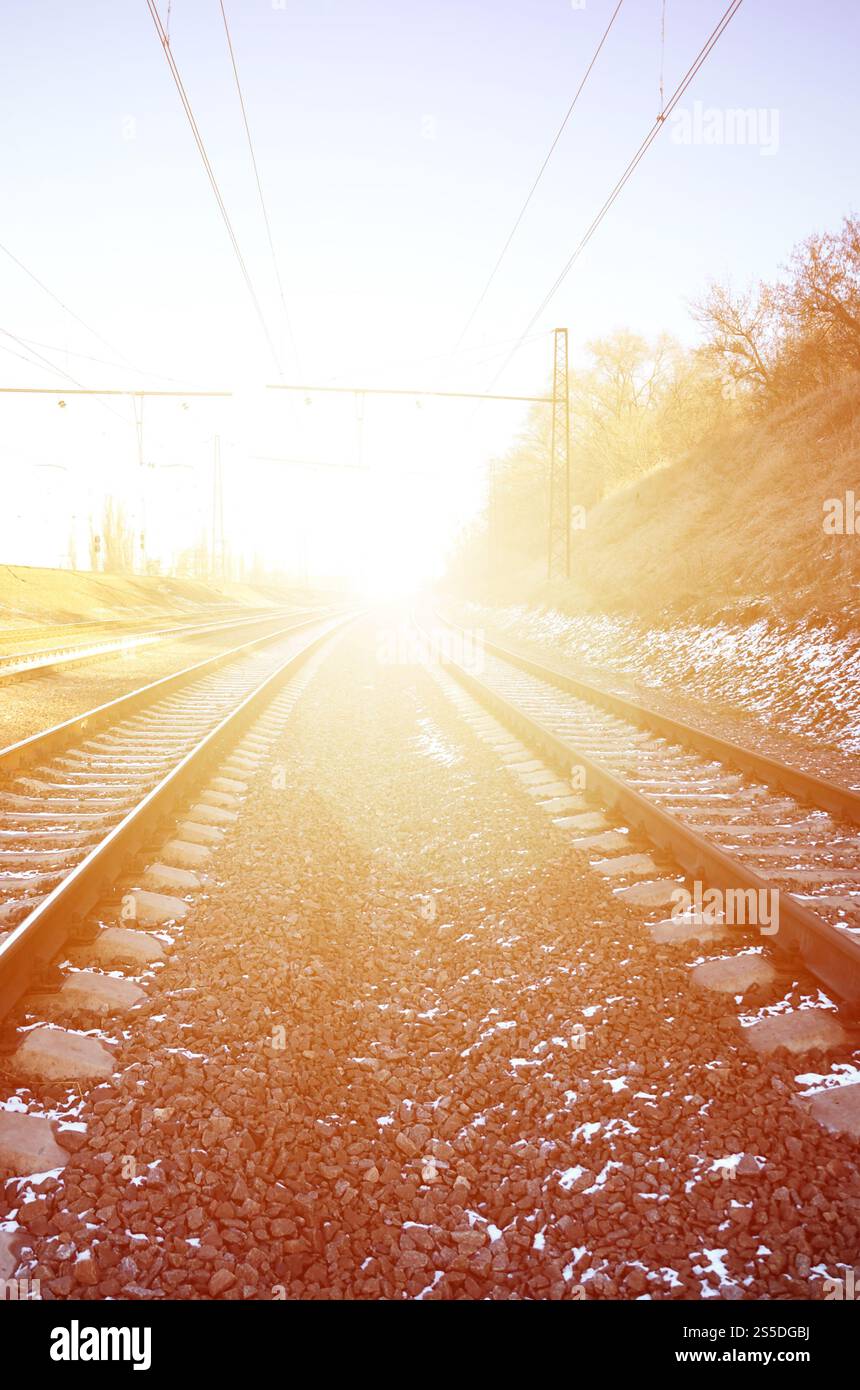Paysage d'un chemin de fer d'hiver russe enneigé sous la lumière du soleil les rails et les traverses sous la neige de décembre. Chemins de fer russes en détail. Hiver Banque D'Images