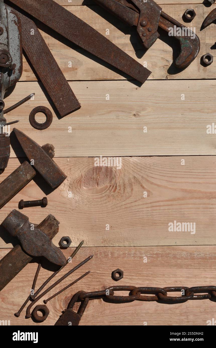Un ensemble d'outils vieux et rouillés pour bricoleur. Beaucoup d'outils ménagers obsolètes en métal rouillé reposent sur une table en bois dans l'atelier. Le concept de Banque D'Images