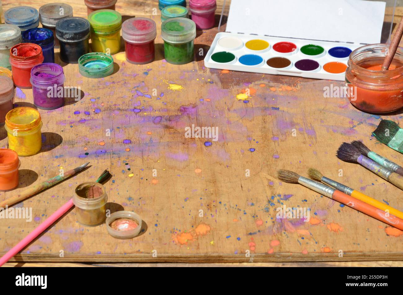 Nature morte, montrant un intérêt pour la peinture à l'aquarelle et choisi Beaucoup de pinceaux, de pots avec de la peinture à l'aquarelle et de gouache usagée reposent sur un vieux bois Banque D'Images
