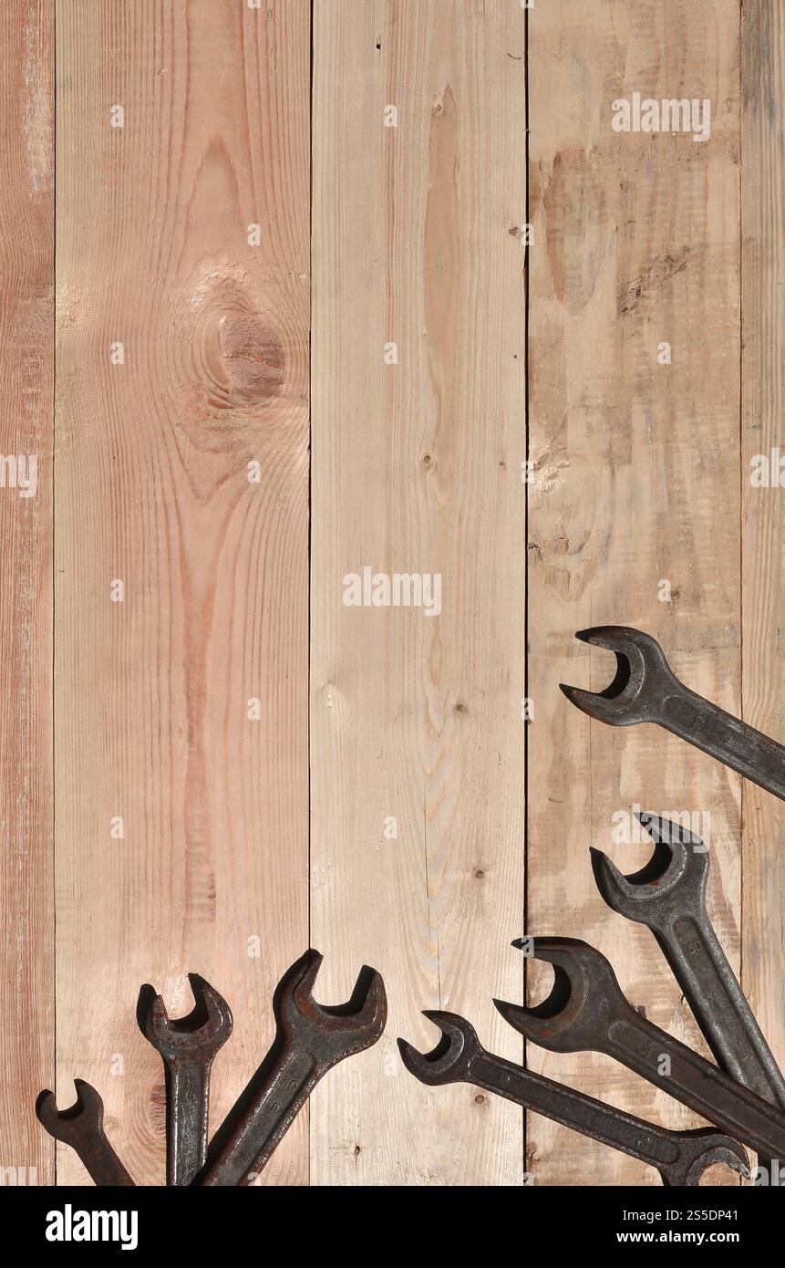 Quelques clés rouillées sur un fond en bois. Des outils ménagers obsolètes en métal rouillé reposent sur une table en bois dans un atelier. Le concept de réparation Banque D'Images